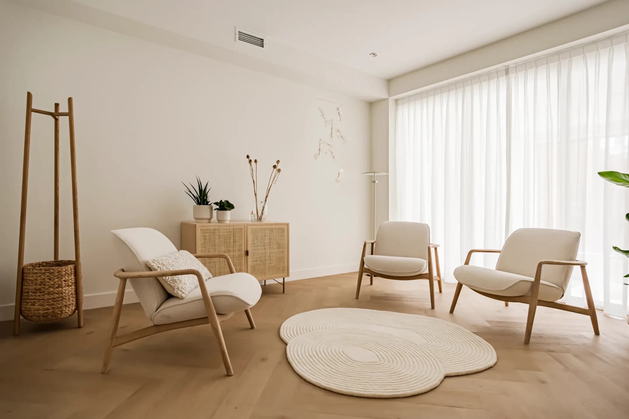 Rustige therapiekamer met drie fauteuils en een rond vloerkleed