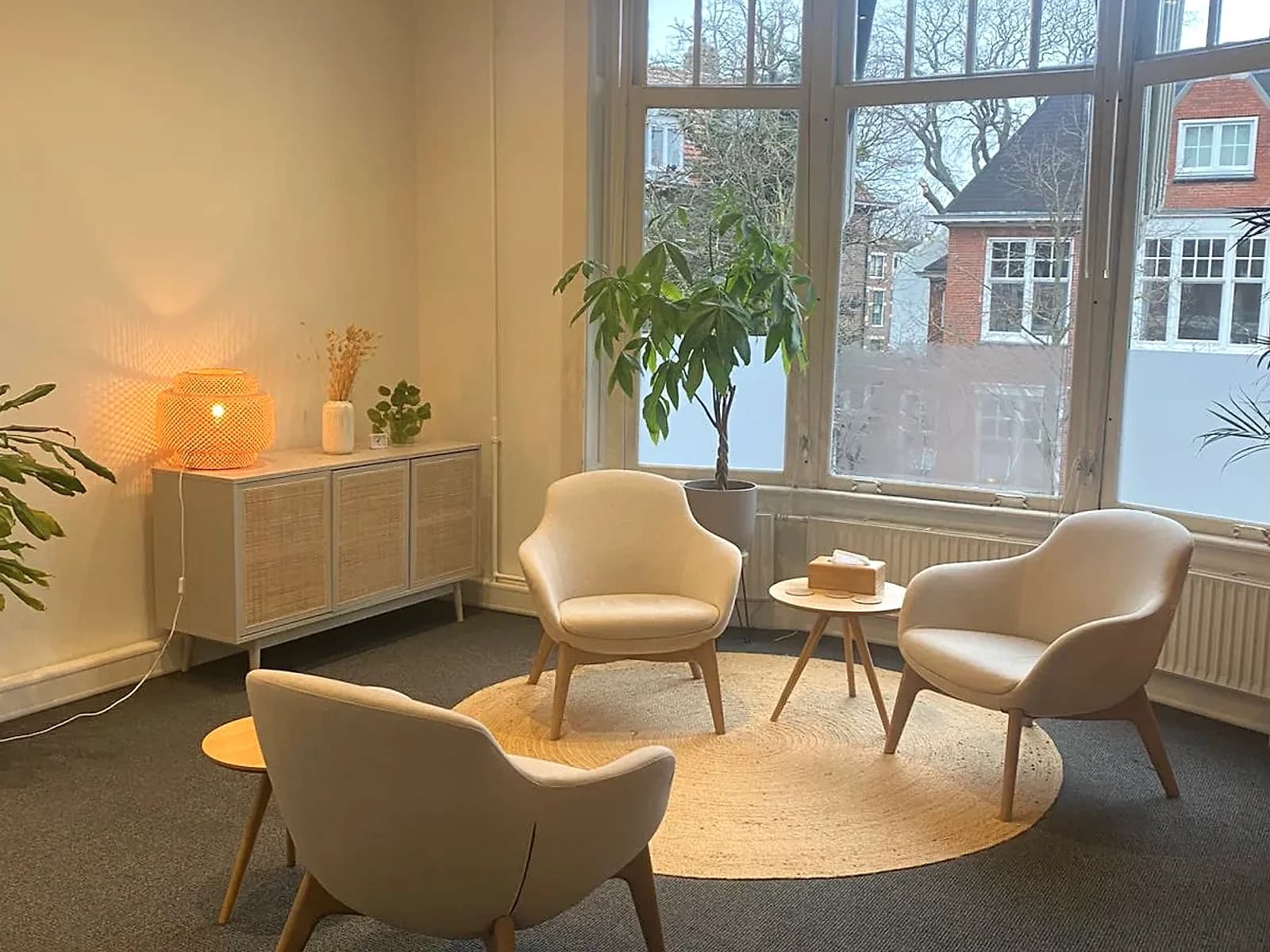 Ruime therapiekamer met warme verlichting en uitzicht