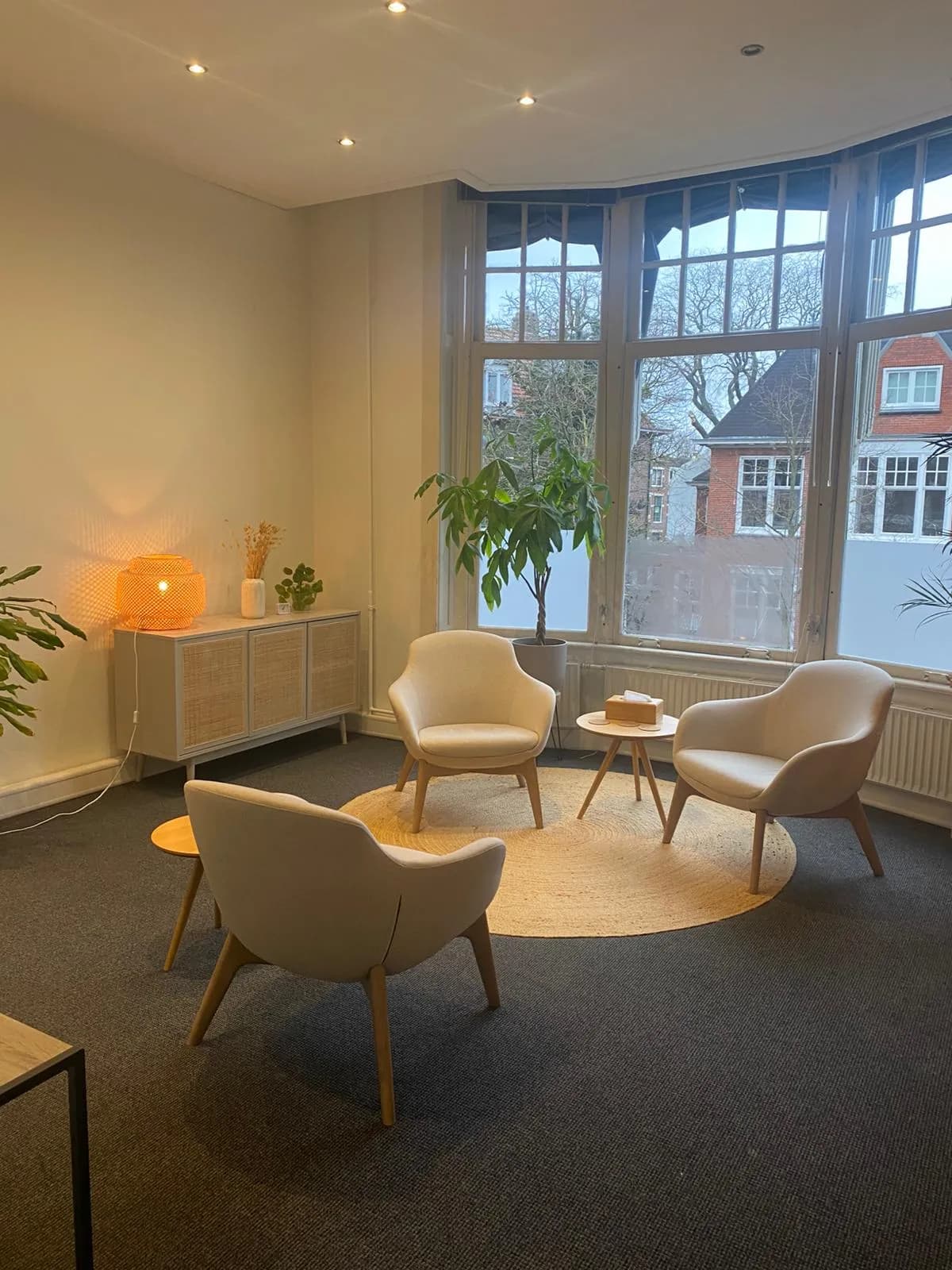 Ruime therapiekamer met warme verlichting en uitzicht